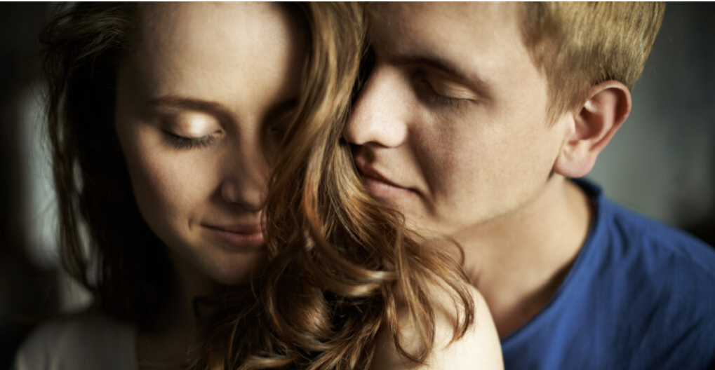 Young man enjoying smell of hair of his sweetheart
