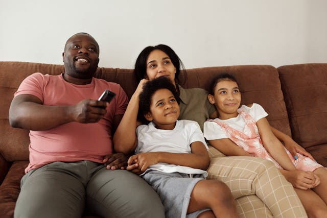 family sitting on a couch watching television