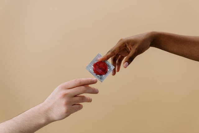 one person handing a condom to another