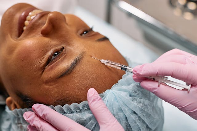 a woman getting a botox injection in her forehead. 