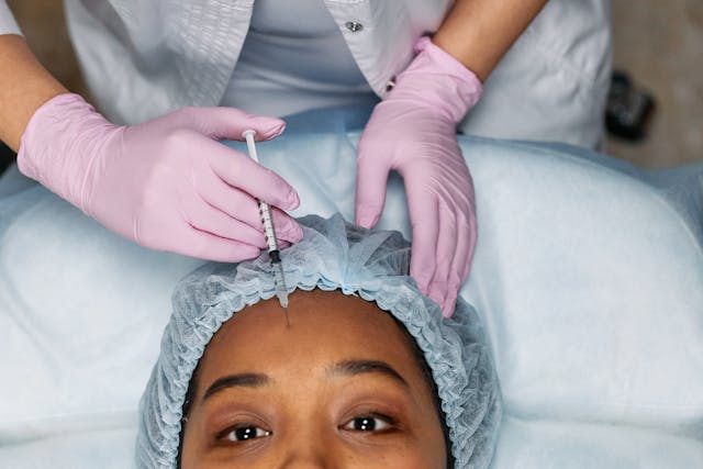 doctor injecting a woman's forehead