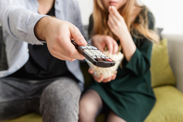 man holding remote control for TV.