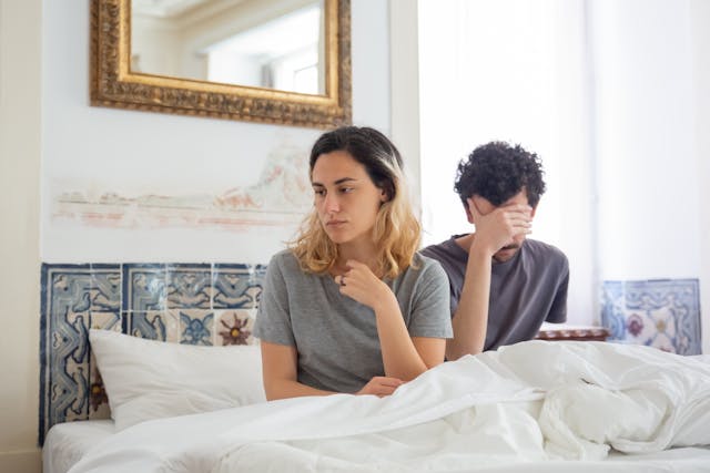 unhappy couple in bed