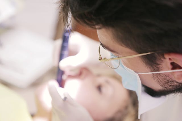 A dentist examining the mouth of a patient