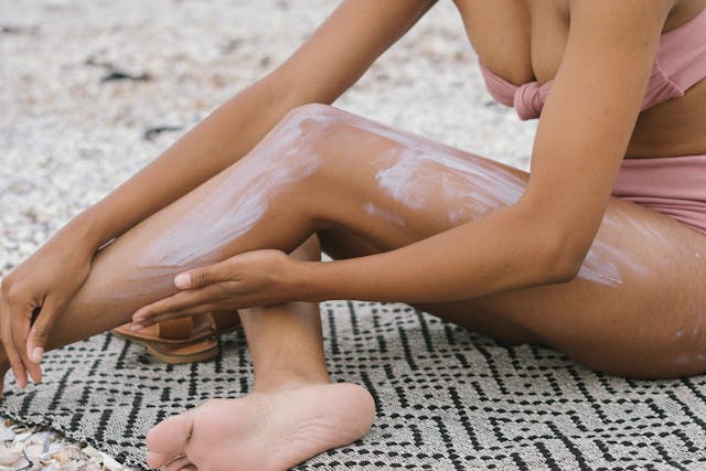 a woman putting on sunscreen