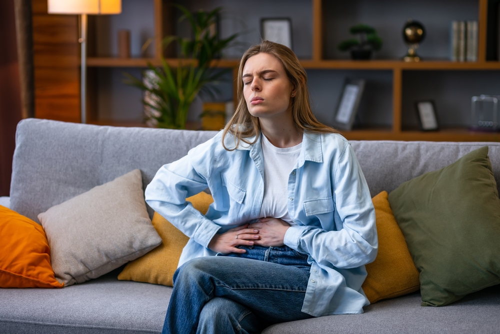 Woman hand in stomach ache, suffer from food poisoning, abdominal pain and colon problem, gastritis. Patient belly, abdomen or inflammation, concept.