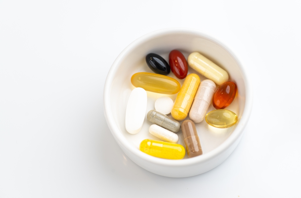 Small Dish of Daily Supplements in Various Colors and Sizes