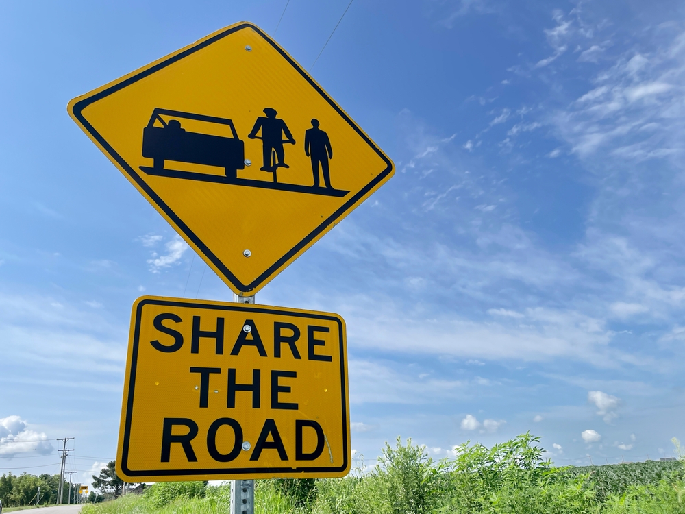 Share the road sign promoting traffic safety for cars, bikes, and pedestrians