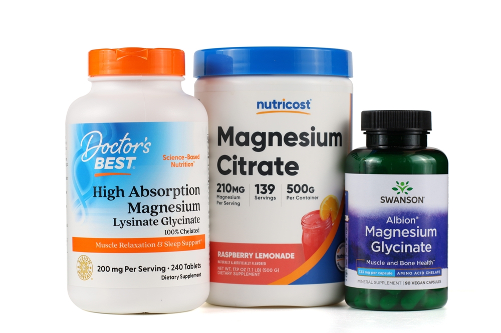 LVIV, UKRAINE - September 30, 2025: Three different magnesium supplements are arranged on a white surface.