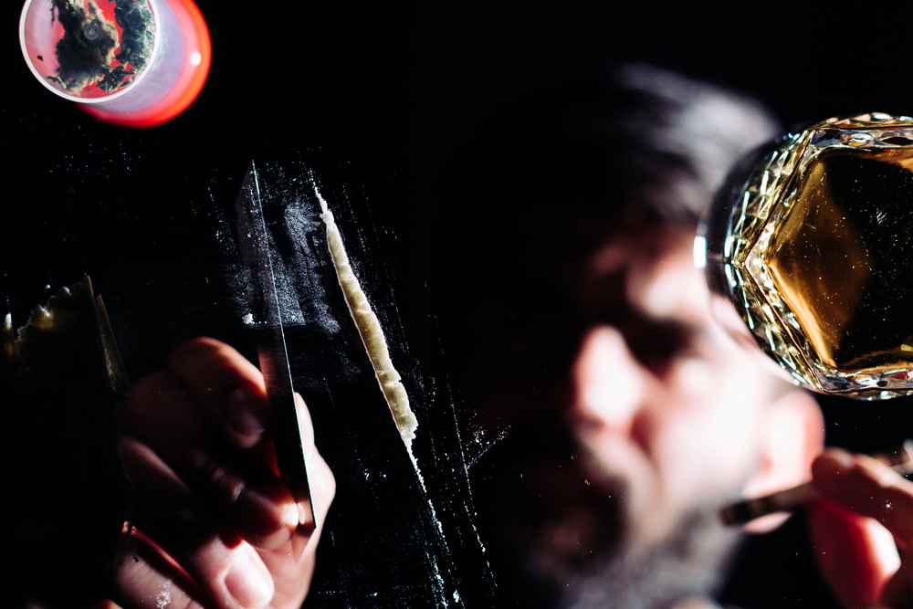 Addicted man preparing a line of cocaine.