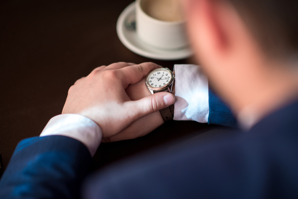 The sedge young man's uplosion keeps track of time, a fit man is waiting for a client