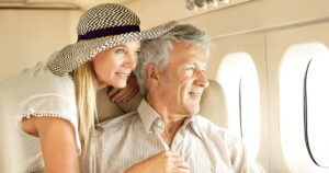 Man and woman flying in a passenger jet looking out the window