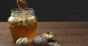 Home Remedy Trend: Garlic, Cloves & Honey — Potential Benefits and Risks Jar of honey with cloves of garlic in it