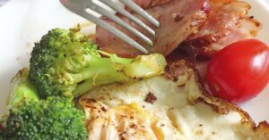 healthy meal featuring grilled chicken, broccoli, and a tomato