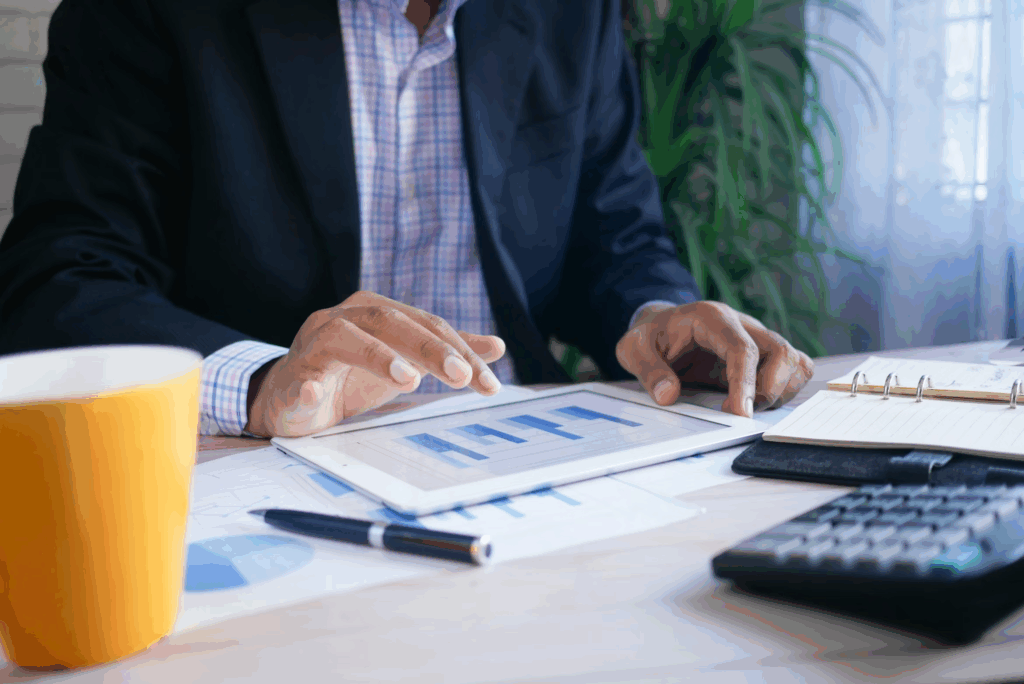 man at desk with papers and calculator