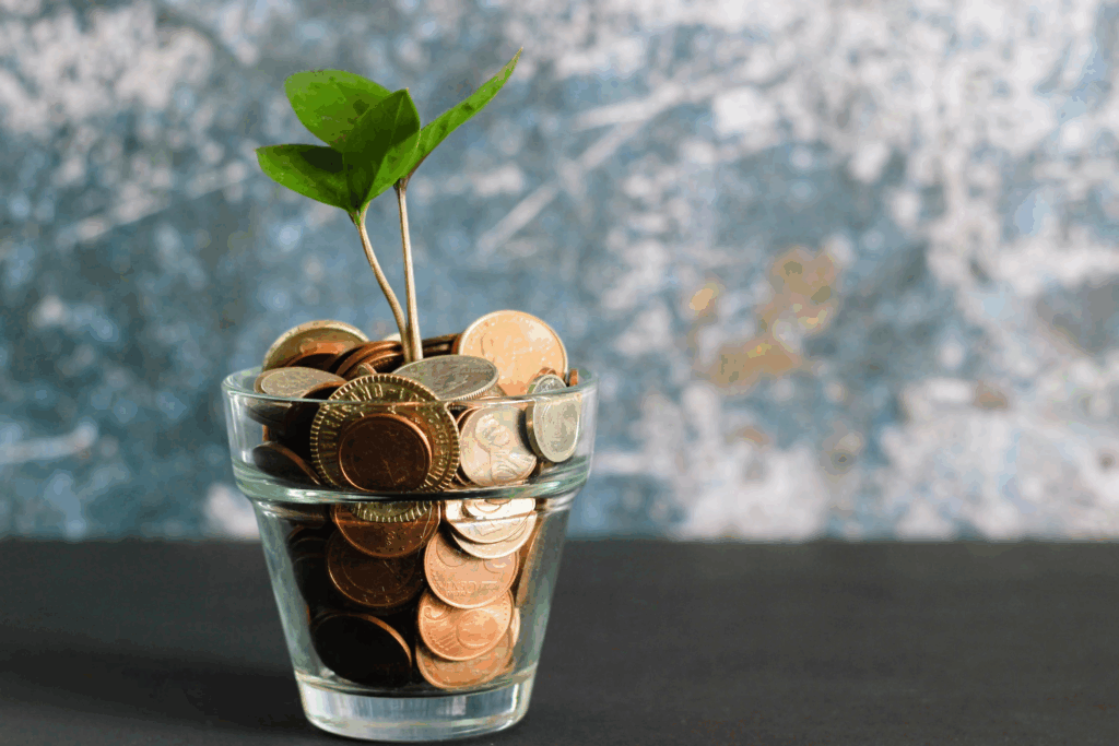 glass of coins with plant growing out
