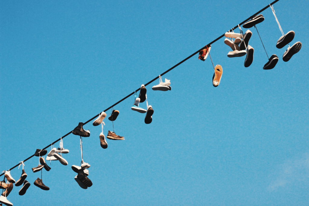several pairs of shoes on power line