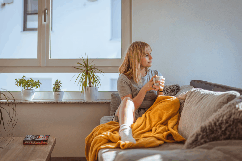 woman with coffee sitting on couch