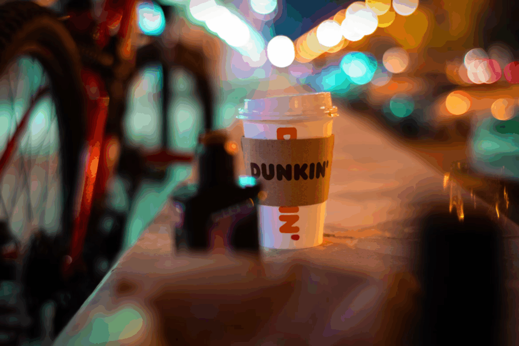cup of takeaway coffee with lid on bokeh background