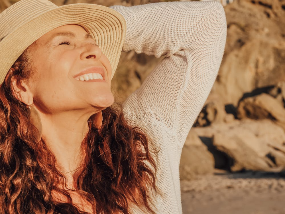 Woman in White Long Sleeve Shirt Wearing White Sun Hat