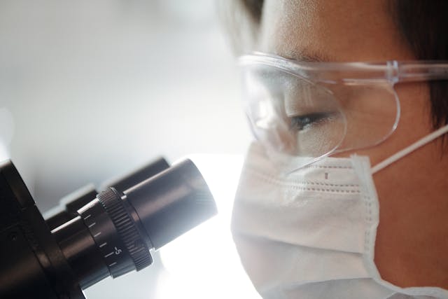 researcher looking through microscope