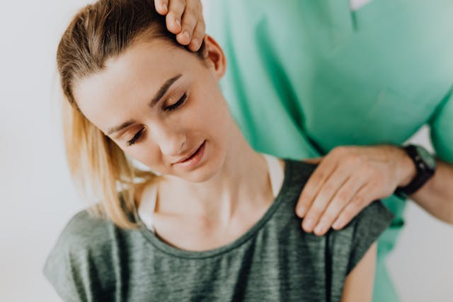 doctor checking woman's neck