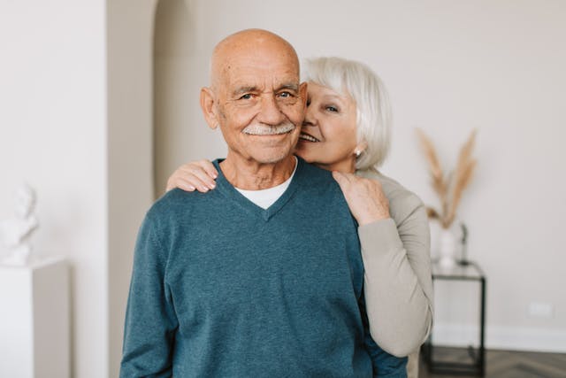graying couple smiling at camera