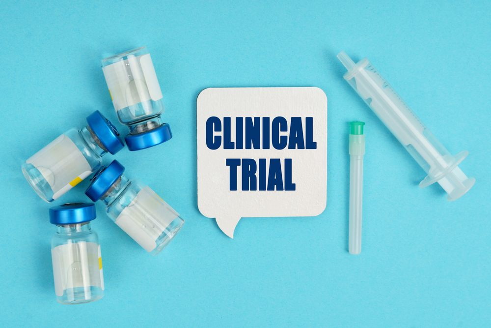 Medicine and health concept. On the table is a syringe, an injection and a white plaque - thoughts with the inscription - CLINICAL TRIAL