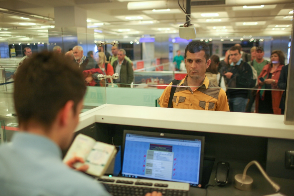 ISTANBUL, TURKEY - 2020: An officer doing passport control, people waiting in line. Istanbul Airport, the international airport serving the city of Istanbul, Turkey.