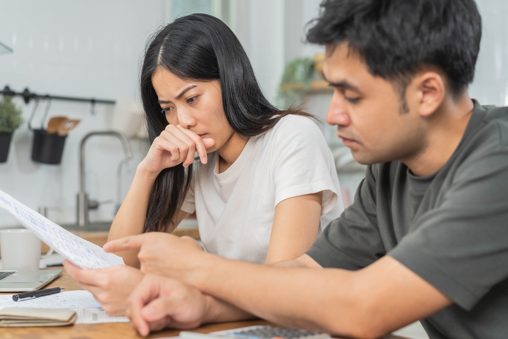 Stressed, hand of asian young couple love family, confused by calculate expense from invoice or bill, have no money to pay. Mortgage, loan causing debt, bankruptcy. Debt problems, Financial people.