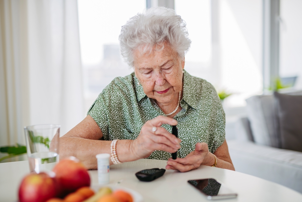 A senior diabetic patient checks his blood sugar level with a Fingerstick Tapping Glucose Meter.