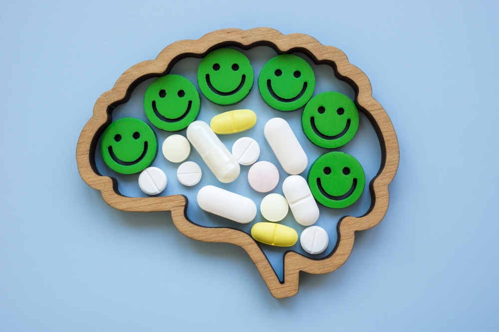 Brain with happy smileys and antidepressant pills or for the treatment of mental illnesses.