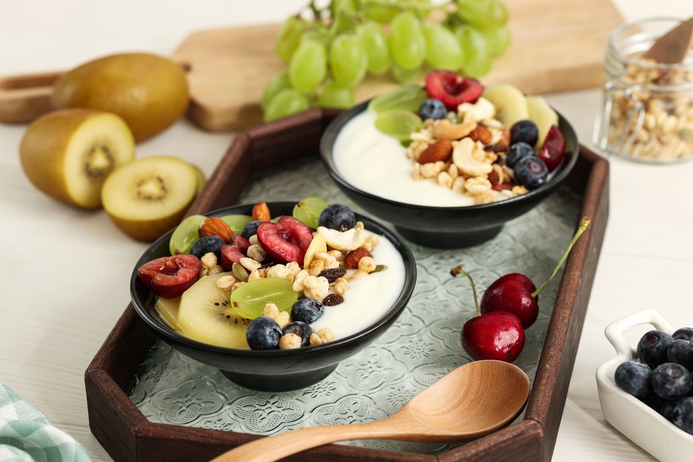Healthy Breakfast, Bowl of Greek Yoghurt with Various Fruit Topping and Cereal. Golden Kiwi, Cherry, Blueberry, and Green Grapes 