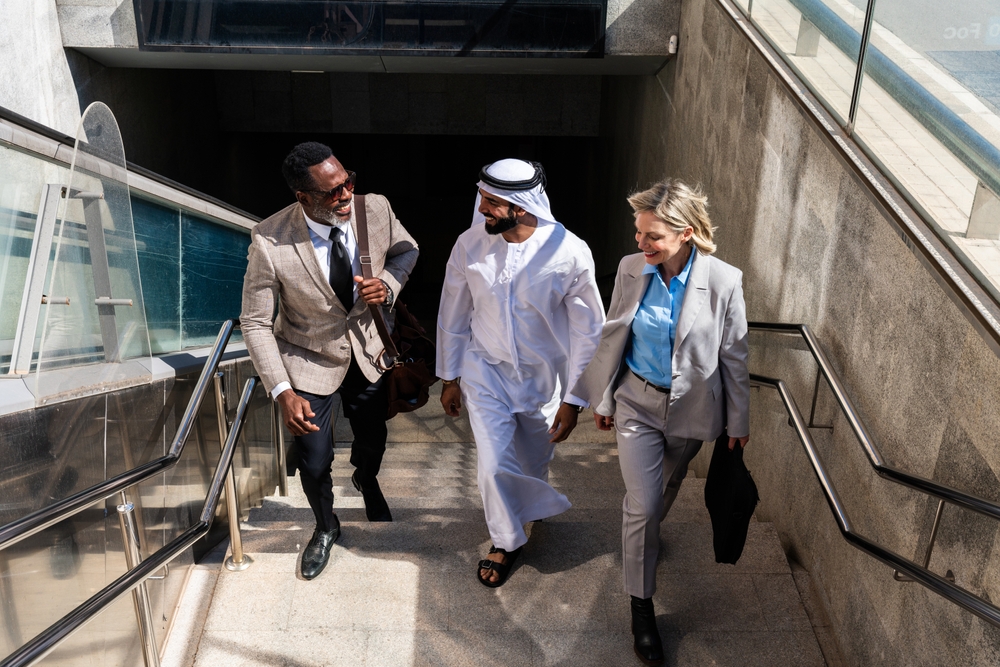 Group of multiethnic business people meeting an emirati businessman - International corporate business team bonding outdoors in the city