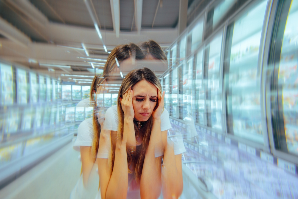 
Woman Suffering from Supermarket syndrome in Bug Store. Woman feeling overwhelmed suffering from dizziness and nausea
