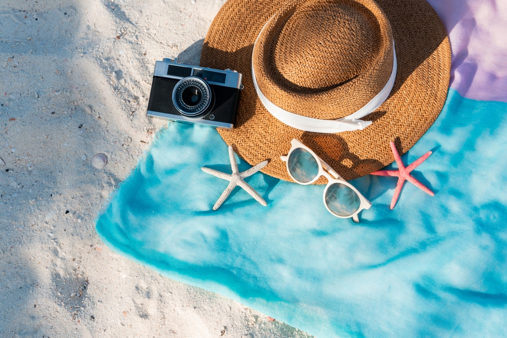 Top view of summer items on sand at the beach. Summer, holiday and relaxation concept. Copy space, flat lay