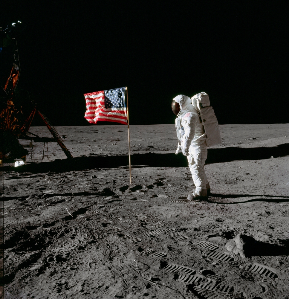 Astronaut Edwin E. Aldrin Jr., beside the deployed United States flag during an Apollo 11 extravehicular activity on the lunar surface. July 24, 19569