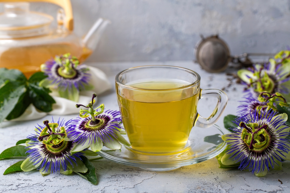 Cup of herbal tea with passiflora caerulea plant on white background. Alternative herb medicine, sedative and calming effect
