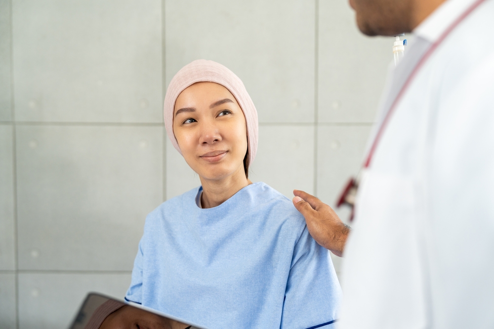 Male doctor visiting female cancer patient with care and compassion in hospital room. Oncology support medical consultation healthcare and hope. Doctor reporting medical test results to the patient