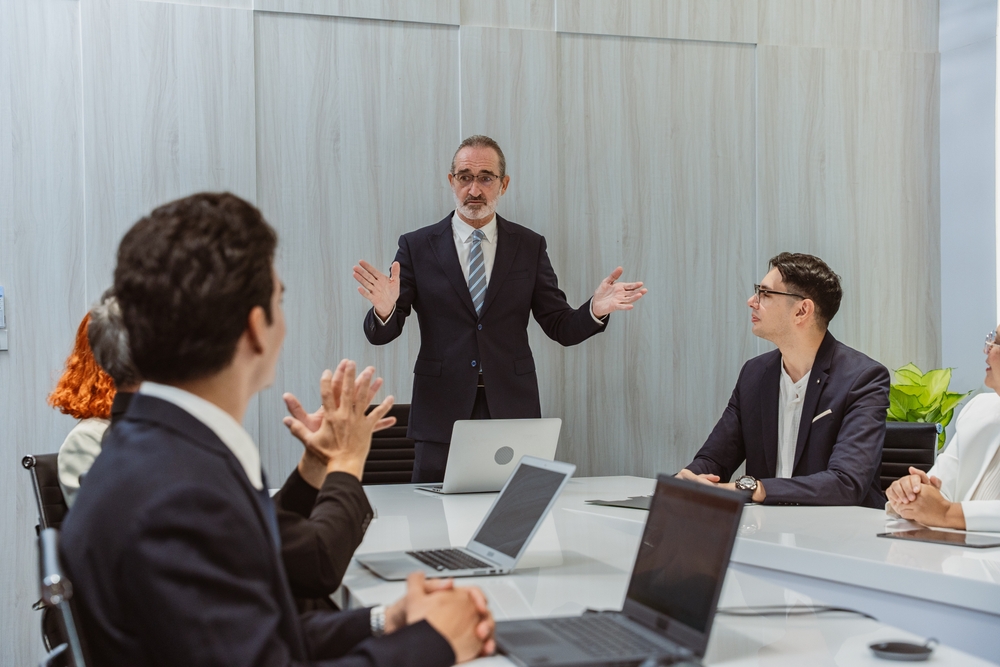 Businessman executive ceo leader discussing project management planning strategy working with diverse colleagues company team at office corporate board group meeting.