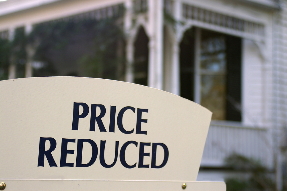 House for sale with "Price reduced" sign
