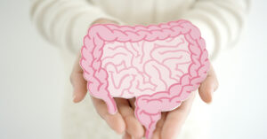 Person holding a pink illustration of the human intestines in their hands