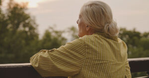 elderly woman looking into distance, pondering