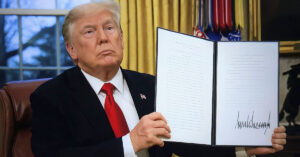 Inside Trump’s Most Debated Executive Orders of 2025 Donald Trump holding up folder containing signed executive order