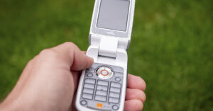 Why Everyone’s Talking About Switching Back to Old Tech in 2026 person holding an older flip phone