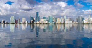 The Flooded Future: How Our Choices Could Submerge the Planet by 2050 Miami cityscape skyline from Rickenbacker causeway looking like sea level has risen