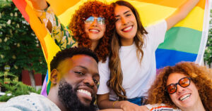 What Is Almondsexuality? A Guide to This Rare Sexual Identity group of 4 adolescents holding rainbow flag