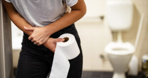 Natural Laxatives: 15 Foods That Help Keep Your Digestive System Moving woman hunched over with toilet paper in her hand