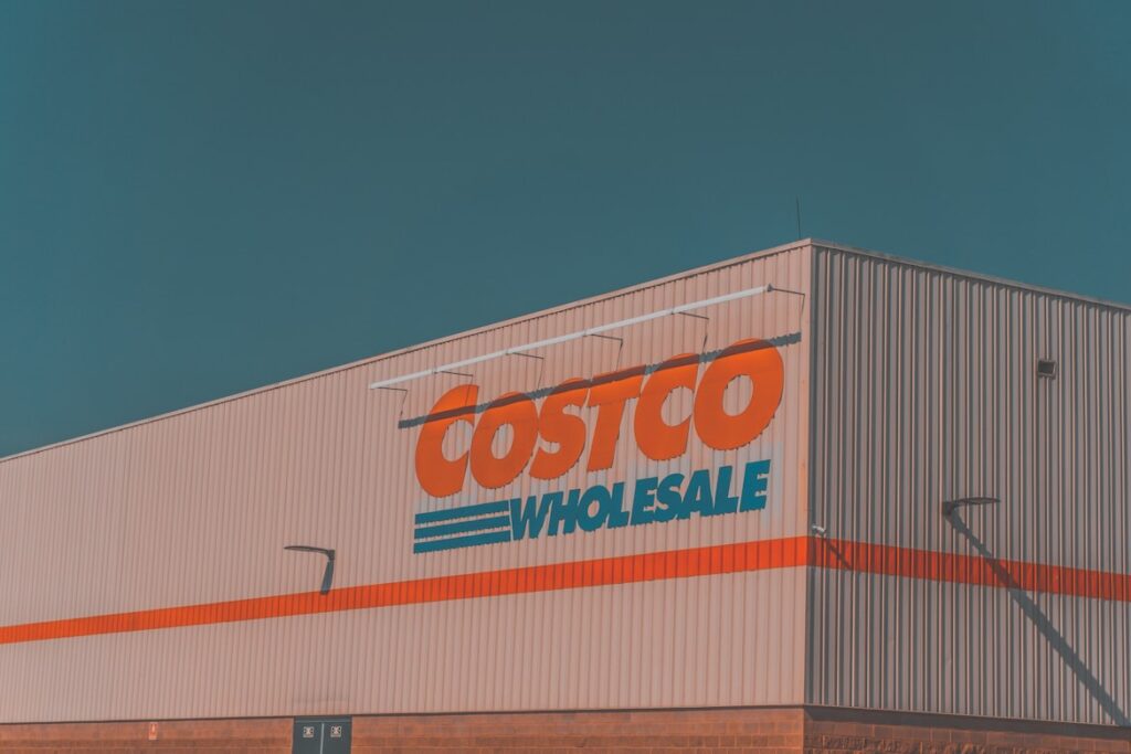 Costco Wholesale warehouse exterior with the red and blue logo on a corrugated metal building.