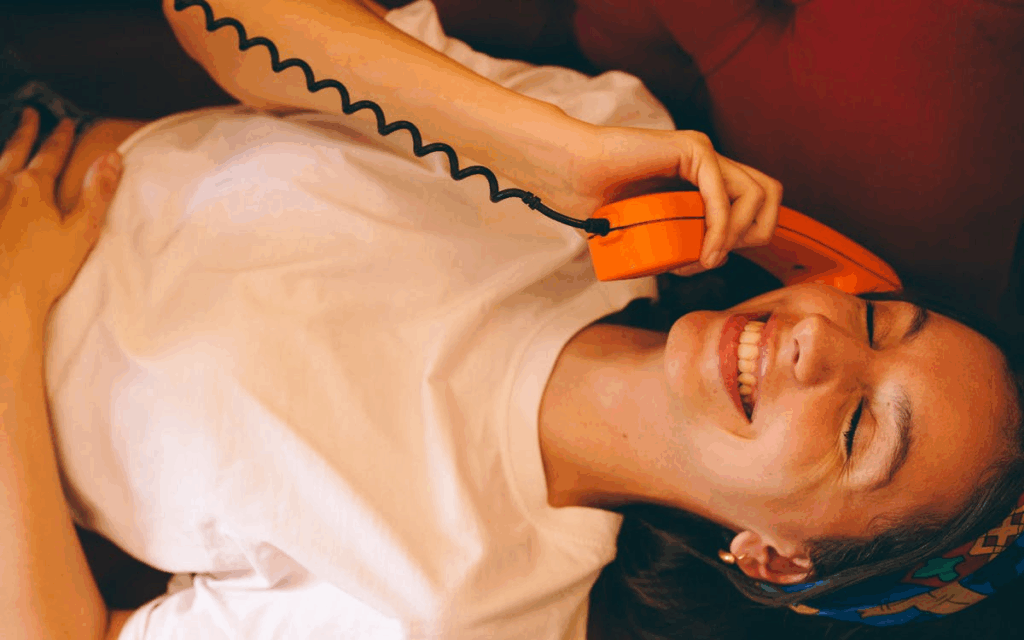 Happy Woman Talking on Retro Orange Phone